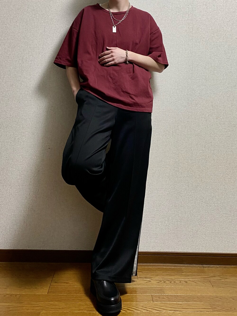 ブラック系のその他パンツ、ブラック系のドレスシューズ、レッド系のTシャツ/カットソーを着用したメンズの春コーディネートの3枚目の写真