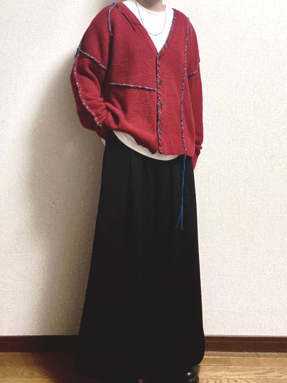 オレンジ系のカーディガン/ボレロ、ホワイト系のTシャツ/カットソー、ブラック系のスラックスを着用したメンズの冬コーディネートの4枚目の写真