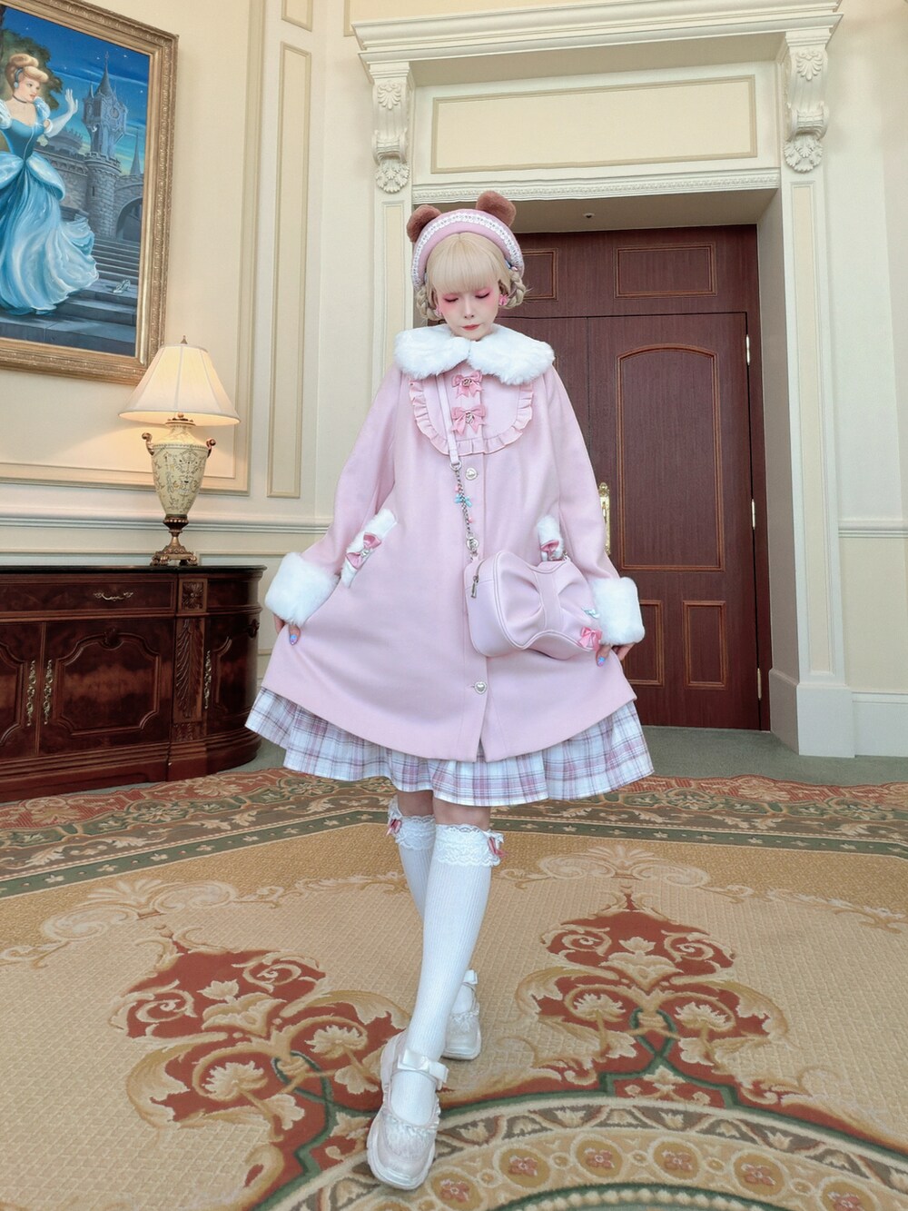 ピンク系のジャケット/アウター、ピンク系のショルダーバッグ、ピンク系のジャンパースカートを着用したレディースの冬コーディネートの2枚目の写真