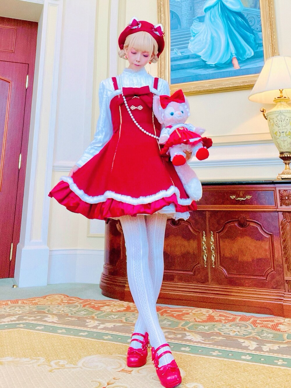 レッド系のチェスターコート、レッド系のパンプスを着用したレディースの冬コーディネートの2枚目の写真