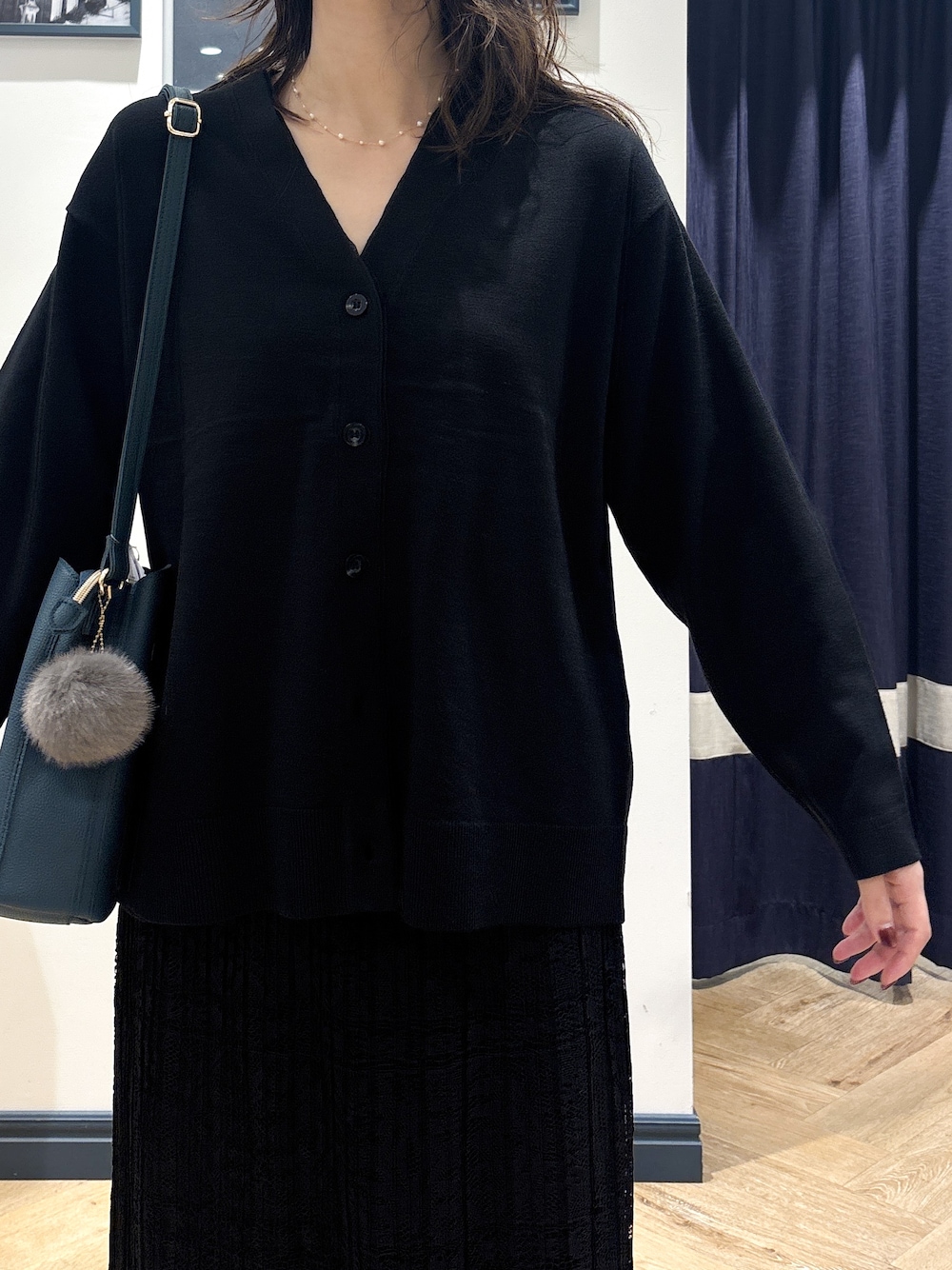 ブラック系のカーディガン/ボレロ、ブラック系のスカート、グリーン系のショルダーバッグを着用したレディースの秋コーディネートの5枚目の写真