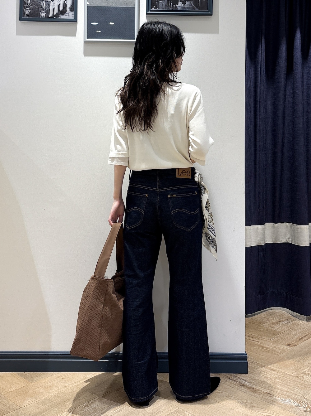 ホワイト系のニット/セーター、ブルー系のデニムパンツ、イエロー系のショルダーバッグを着用したレディースの秋コーディネートの3枚目の写真