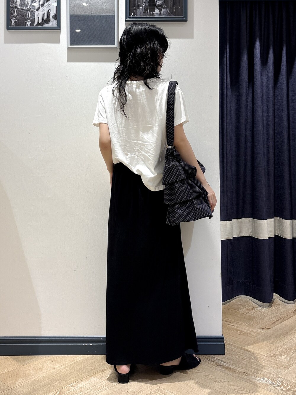ホワイト系のTシャツ/カットソー、ブラック系のスカート、ブラック系のショルダーバッグを着用したレディースの夏コーディネートの3枚目の写真
