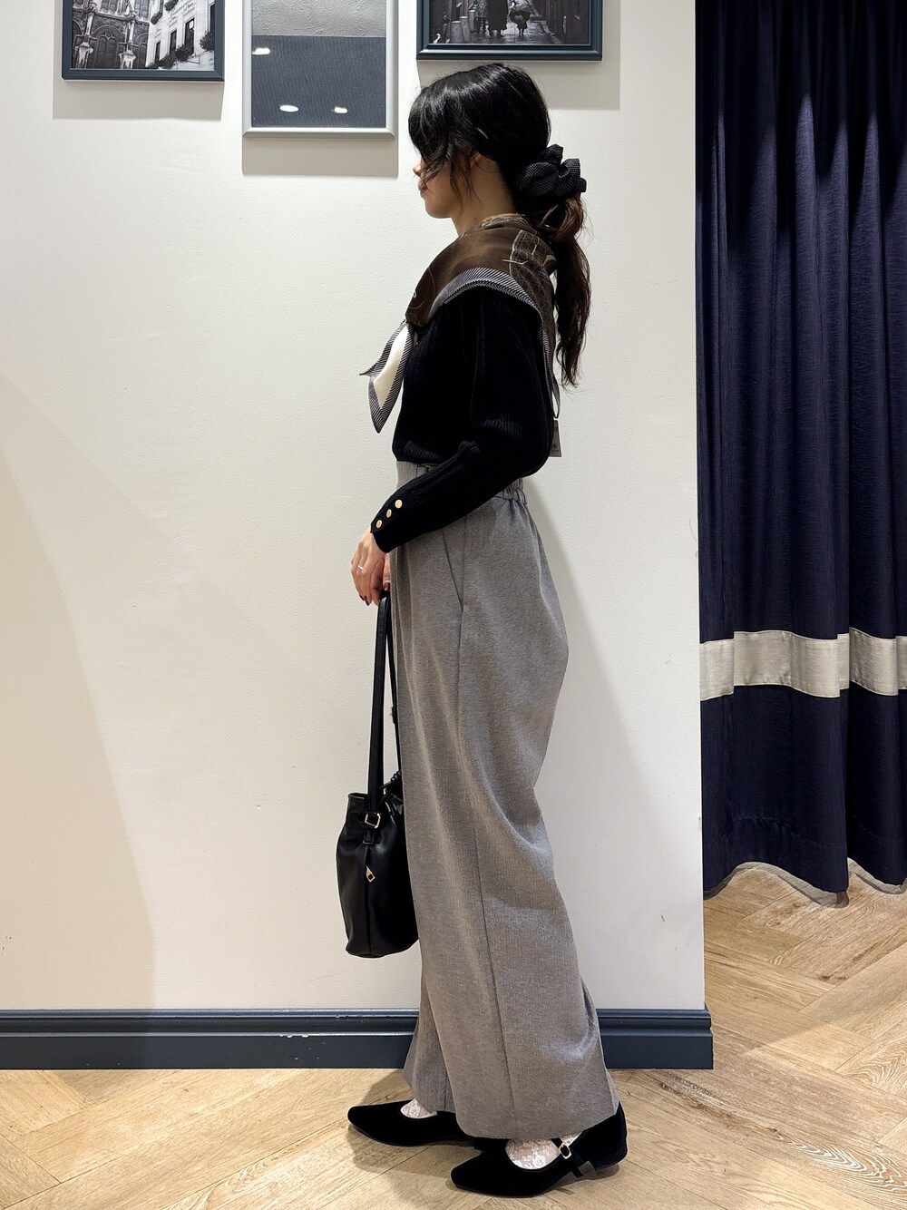 ブラック系のニット/セーター、グレー系のその他パンツ、ブラック系のショルダーバッグを着用したレディースの秋コーディネートの2枚目の写真