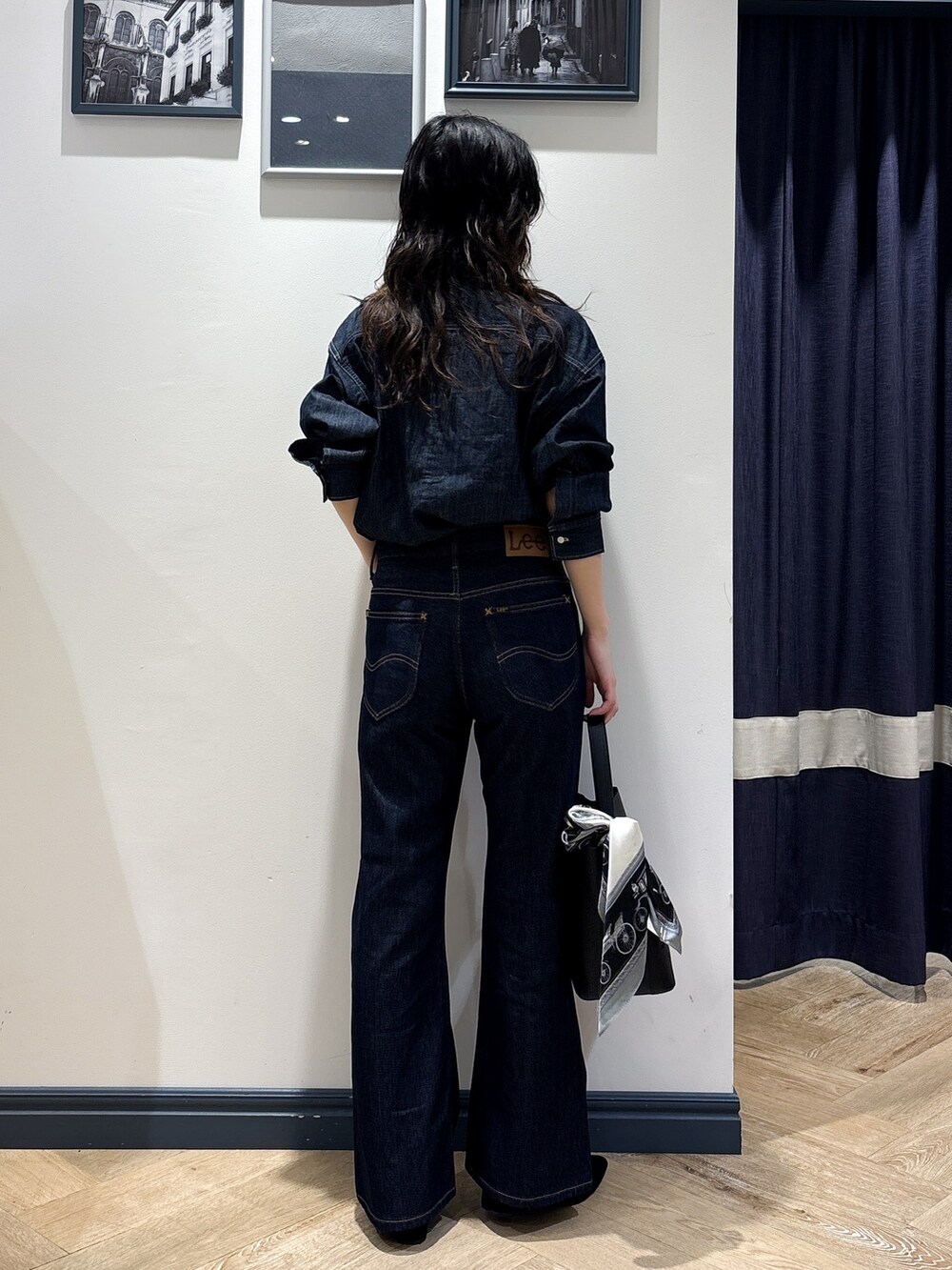 ブルー系のシャツ/ブラウス、ブルー系のデニムパンツ、ブラック系のショルダーバッグを着用したレディースの秋コーディネートの3枚目の写真