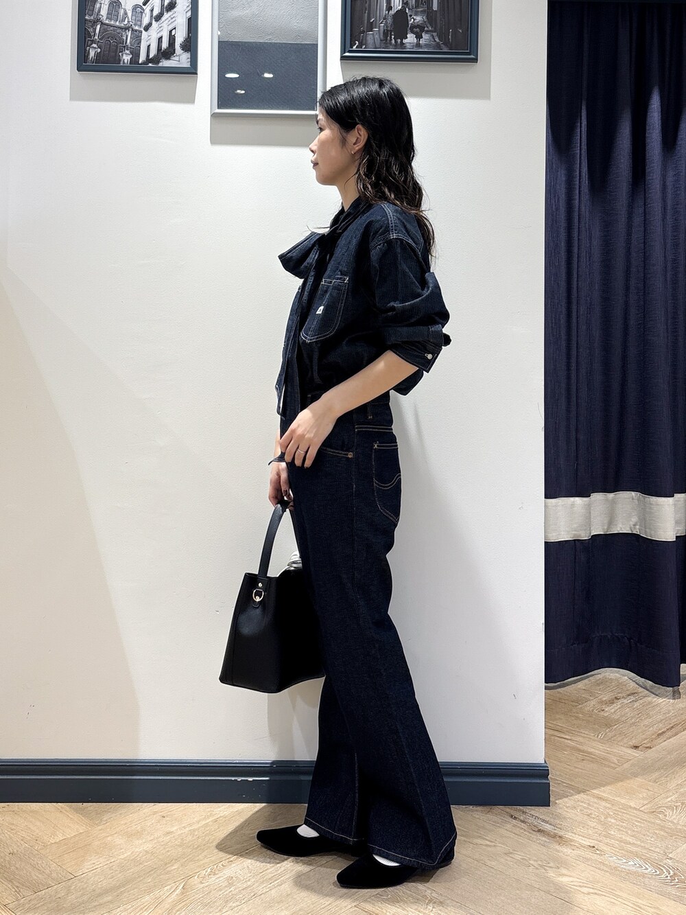 ブルー系のシャツ/ブラウス、ブルー系のデニムパンツ、ブラック系のショルダーバッグを着用したレディースの秋コーディネートの2枚目の写真