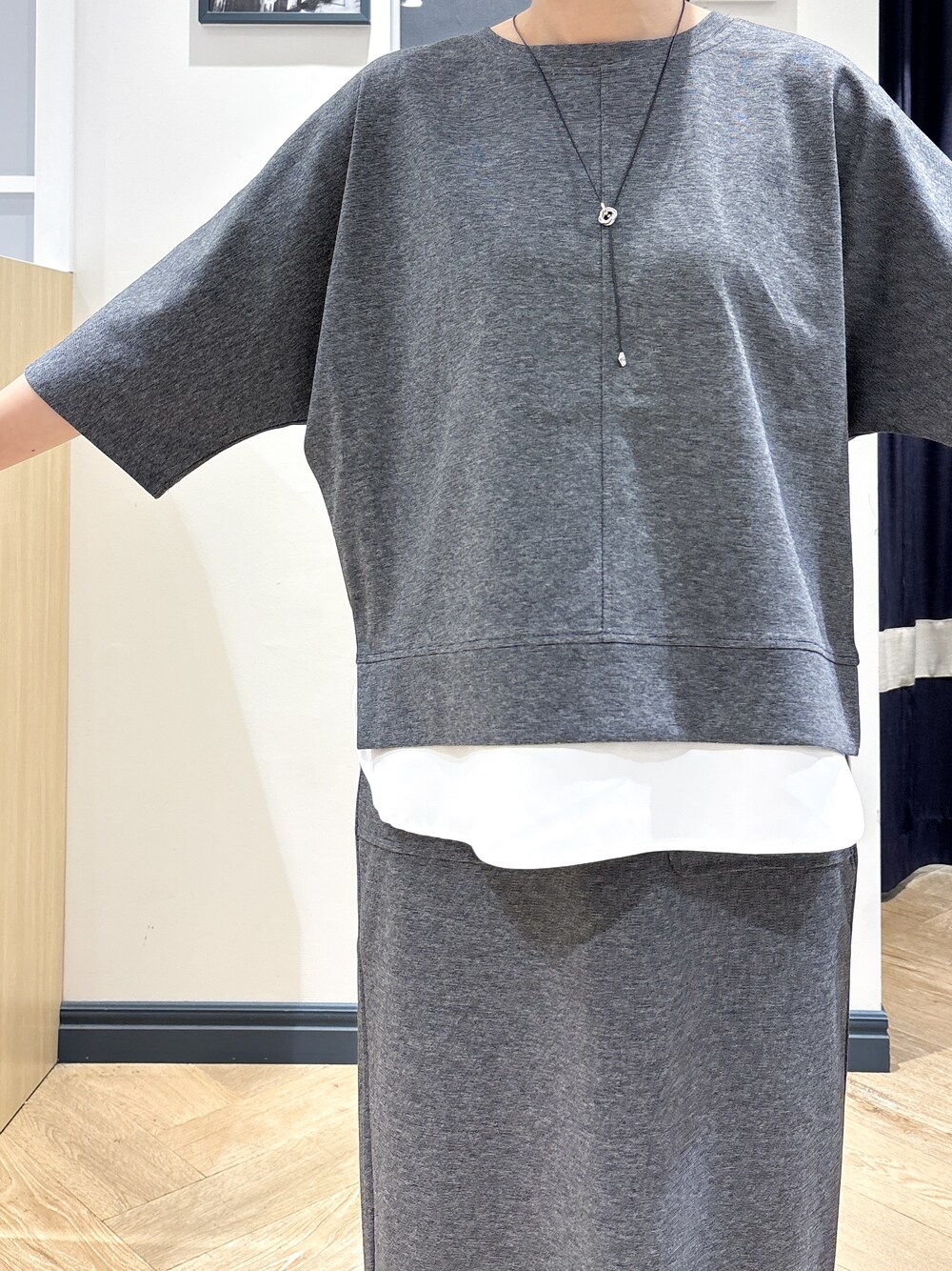 ブラウン系のショルダーバッグ、シルバー系のネックレスを着用したレディースの夏コーディネートの4枚目の写真