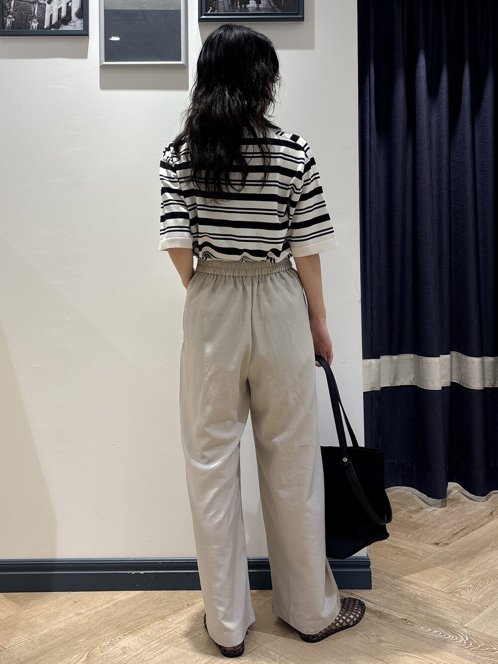 ホワイト系のニット/セーター、ベージュ系のその他パンツ、ブラック系のトートバッグを着用したレディースの夏コーディネートの3枚目の写真