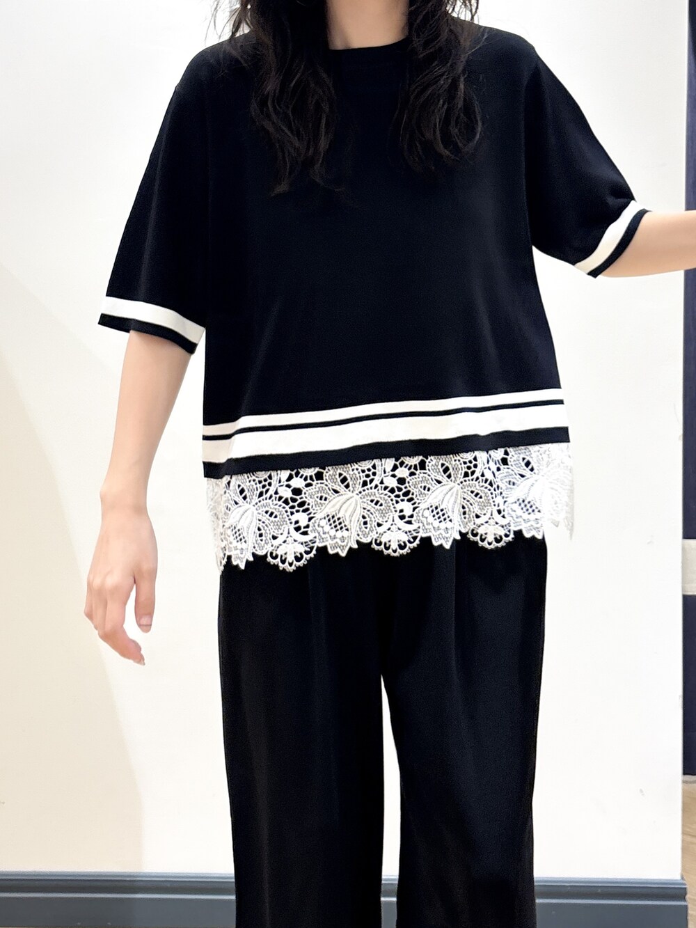 ブラック系のニット/セーター、ブラック系のその他パンツ、ベージュ系のバックパック/リュックを着用したレディースの夏コーディネートの4枚目の写真