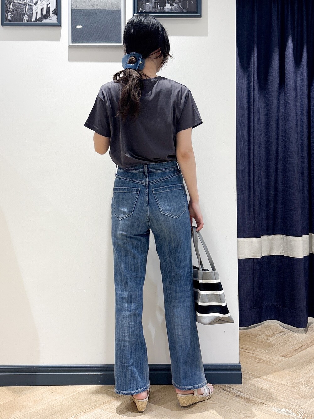 グレー系のTシャツ/カットソー、ブルー系のデニムパンツ、グレー系のトートバッグを着用したレディースの夏コーディネートの3枚目の写真