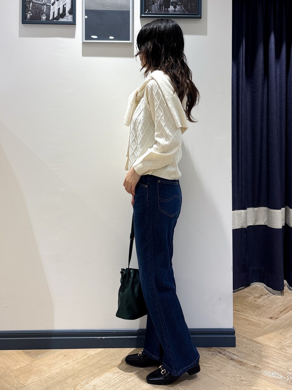 ホワイト系のカーディガン/ボレロ、ホワイト系のニット/セーター、ブルー系のデニムパンツを着用したレディースの秋コーディネートの2枚目の写真