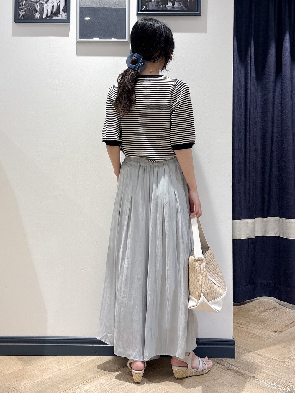 ブラック系のニット/セーター、ブルー系のその他パンツ、ホワイト系のショルダーバッグを着用したレディースの夏コーディネートの3枚目の写真