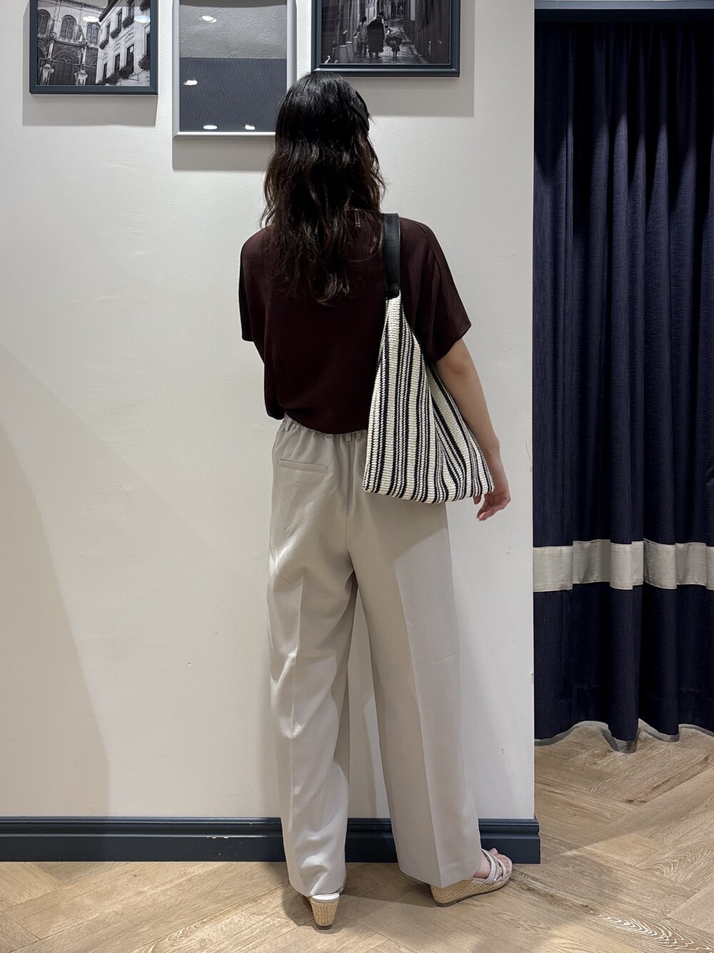 ブラウン系のニット/セーター、ベージュ系のその他パンツ、ブラック系のショルダーバッグを着用したレディースの夏コーディネートの3枚目の写真