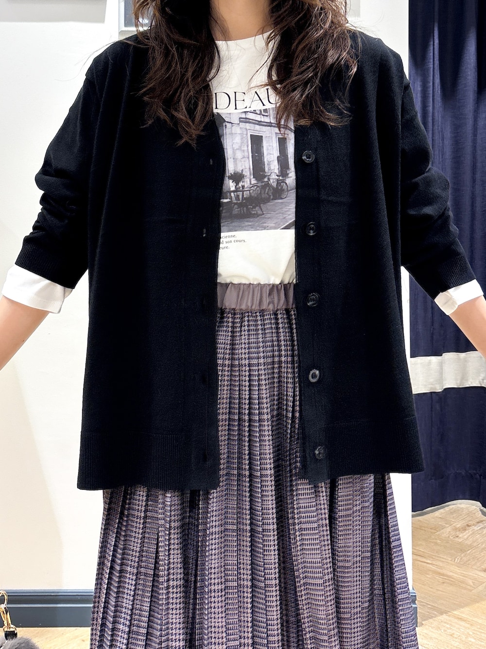 ブラック系のカーディガン/ボレロ、ホワイト系のTシャツ/カットソー、グレー系のスカートを着用したレディースの秋コーディネートの4枚目の写真