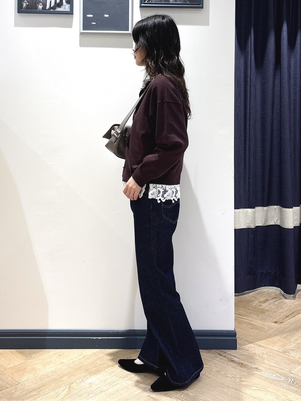 ブラウン系のカーディガン/ボレロ、ホワイト系のTシャツ/カットソー、ブルー系のデニムパンツを着用したレディースの秋コーディネートの2枚目の写真