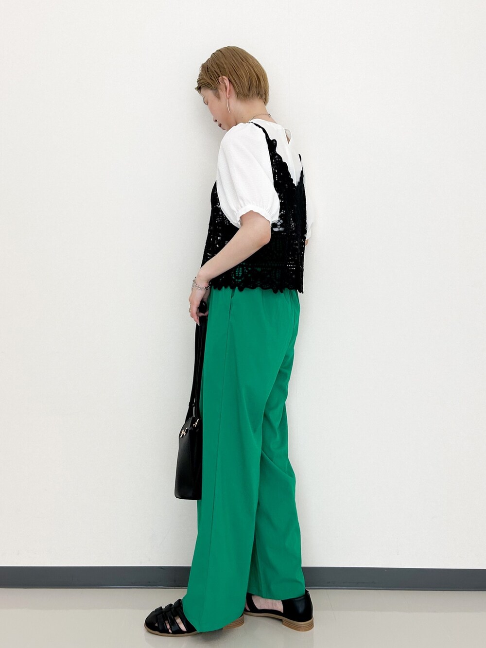 ブラック系のシャツ/ブラウス、グリーン系のその他パンツ、ブラック系のショルダーバッグを着用したレディースの春コーディネートの2枚目の写真