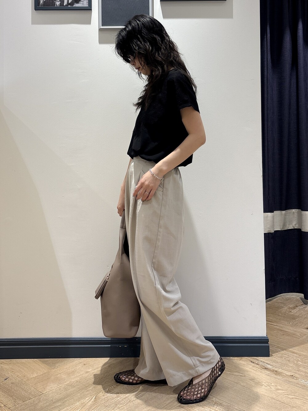 ブラック系のTシャツ/カットソー、ベージュ系のその他パンツ、ブラウン系のトートバッグを着用したレディースの夏コーディネートの2枚目の写真