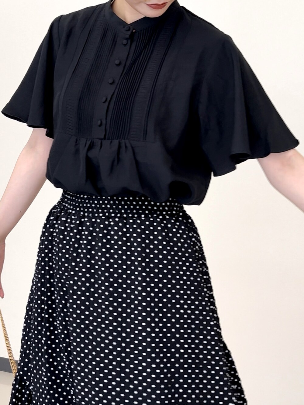 ブラック系のシャツ/ブラウス、ホワイト系のショルダーバッグ、ブラック系のパンプスを着用したレディースの夏コーディネートの2枚目の写真