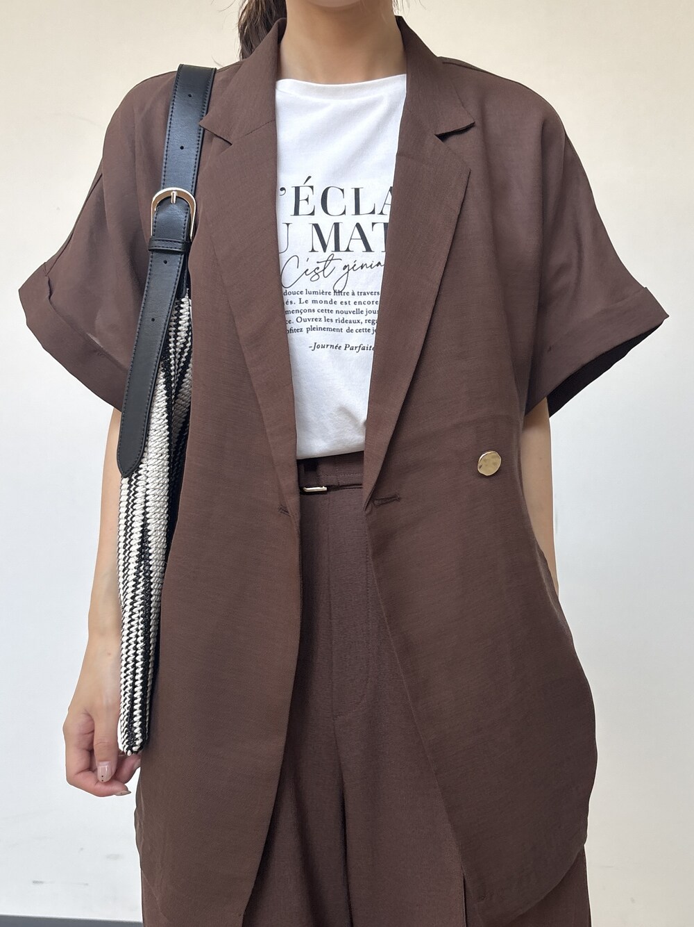 ホワイト系のTシャツ/カットソー、ブラック系のショルダーバッグを着用したレディースの夏コーディネートの4枚目の写真