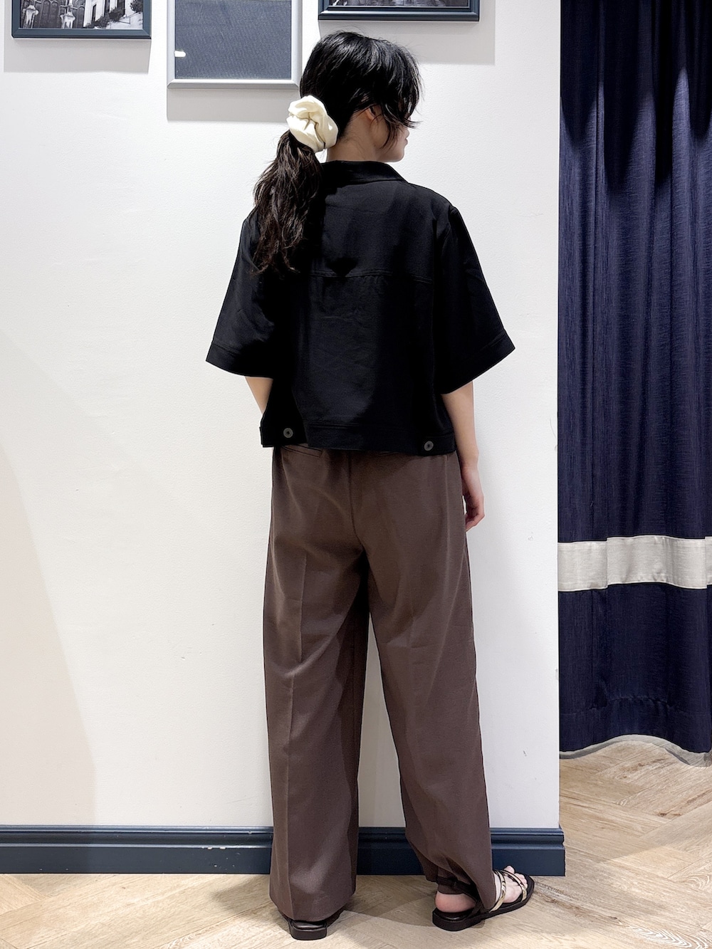 ブラック系のテーラードジャケット、ホワイト系のタンクトップ、ブラウン系のその他パンツを着用したレディースの夏コーディネートの3枚目の写真