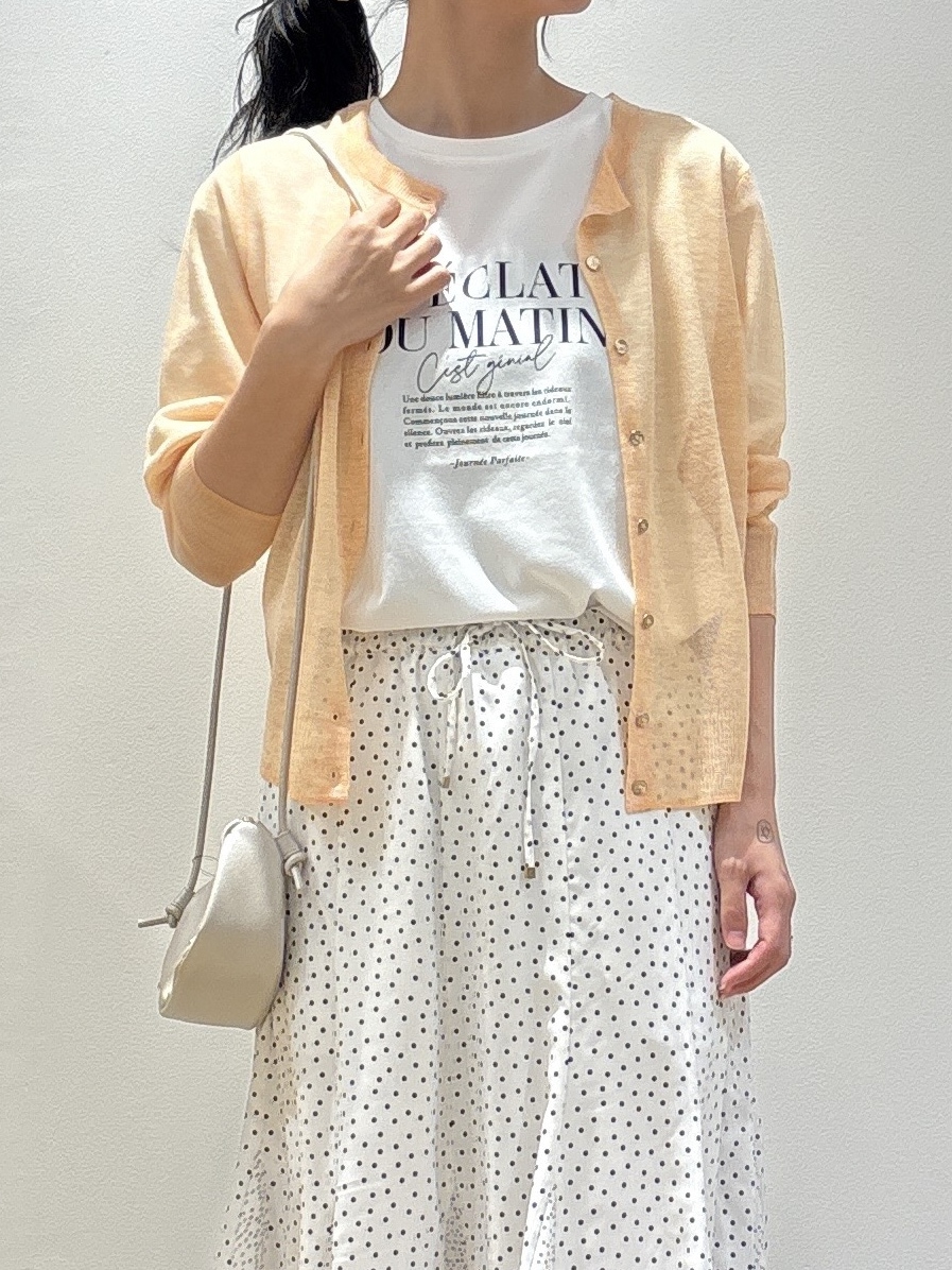 ホワイト系のショルダーバッグ、オレンジ系のカーディガン/ボレロ、ホワイト系のTシャツ/カットソーを着用したレディースの春コーディネートの4枚目の写真