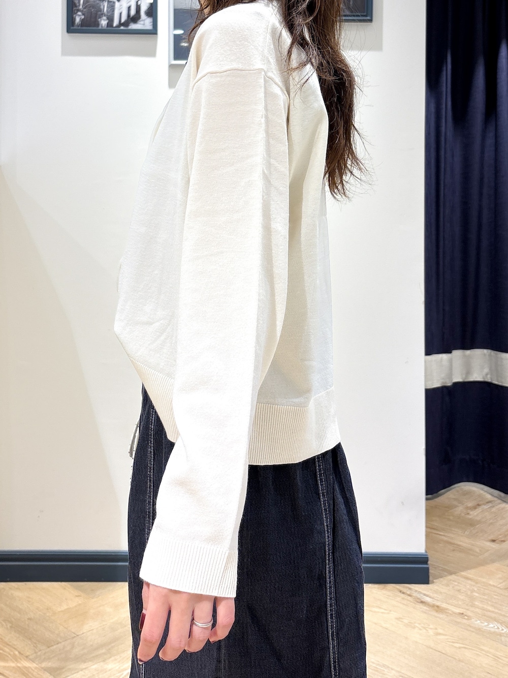 ホワイト系のカーディガン/ボレロ、グレー系のタンクトップ、ブラック系のデニムスカートを着用したレディースの秋コーディネートの5枚目の写真