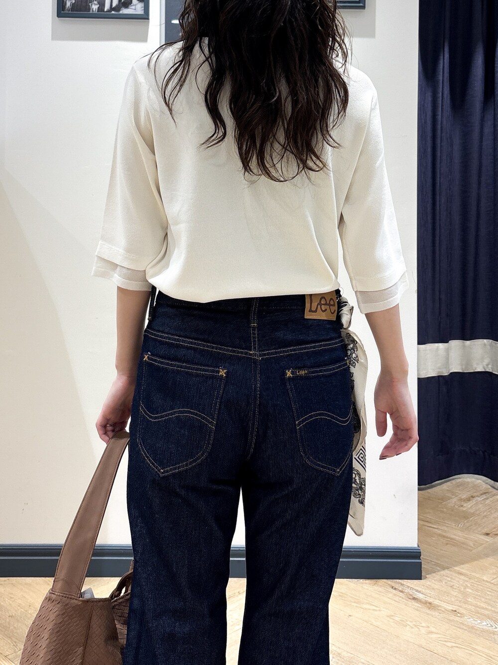 ホワイト系のニット/セーター、ブルー系のデニムパンツ、イエロー系のショルダーバッグを着用したレディースの秋コーディネートの6枚目の写真