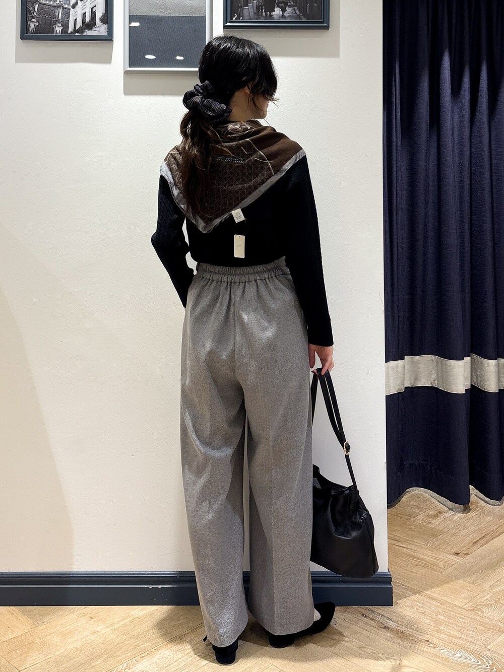 ブラック系のニット/セーター、グレー系のその他パンツ、ブラック系のショルダーバッグを着用したレディースの秋コーディネートの3枚目の写真