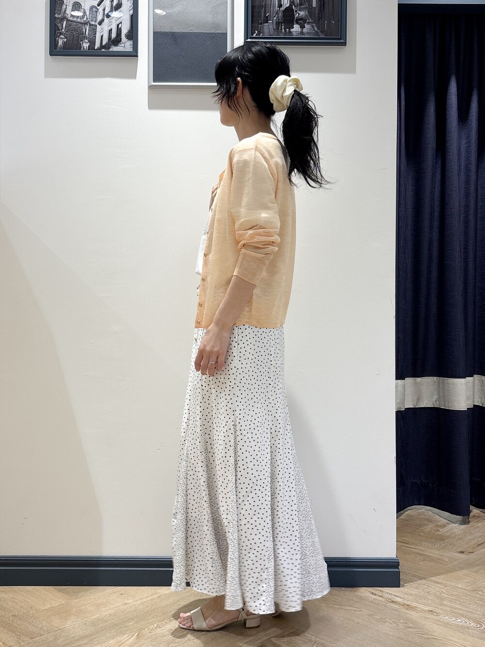 ホワイト系のショルダーバッグ、オレンジ系のカーディガン/ボレロ、ホワイト系のTシャツ/カットソーを着用したレディースの春コーディネートの2枚目の写真