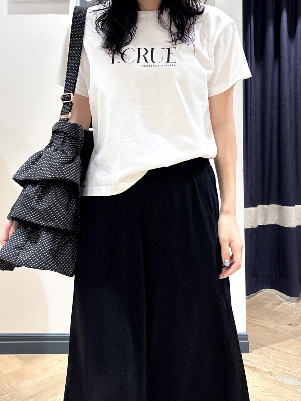 ホワイト系のTシャツ/カットソー、ブラック系のスカート、ブラック系のショルダーバッグを着用したレディースの夏コーディネートの4枚目の写真