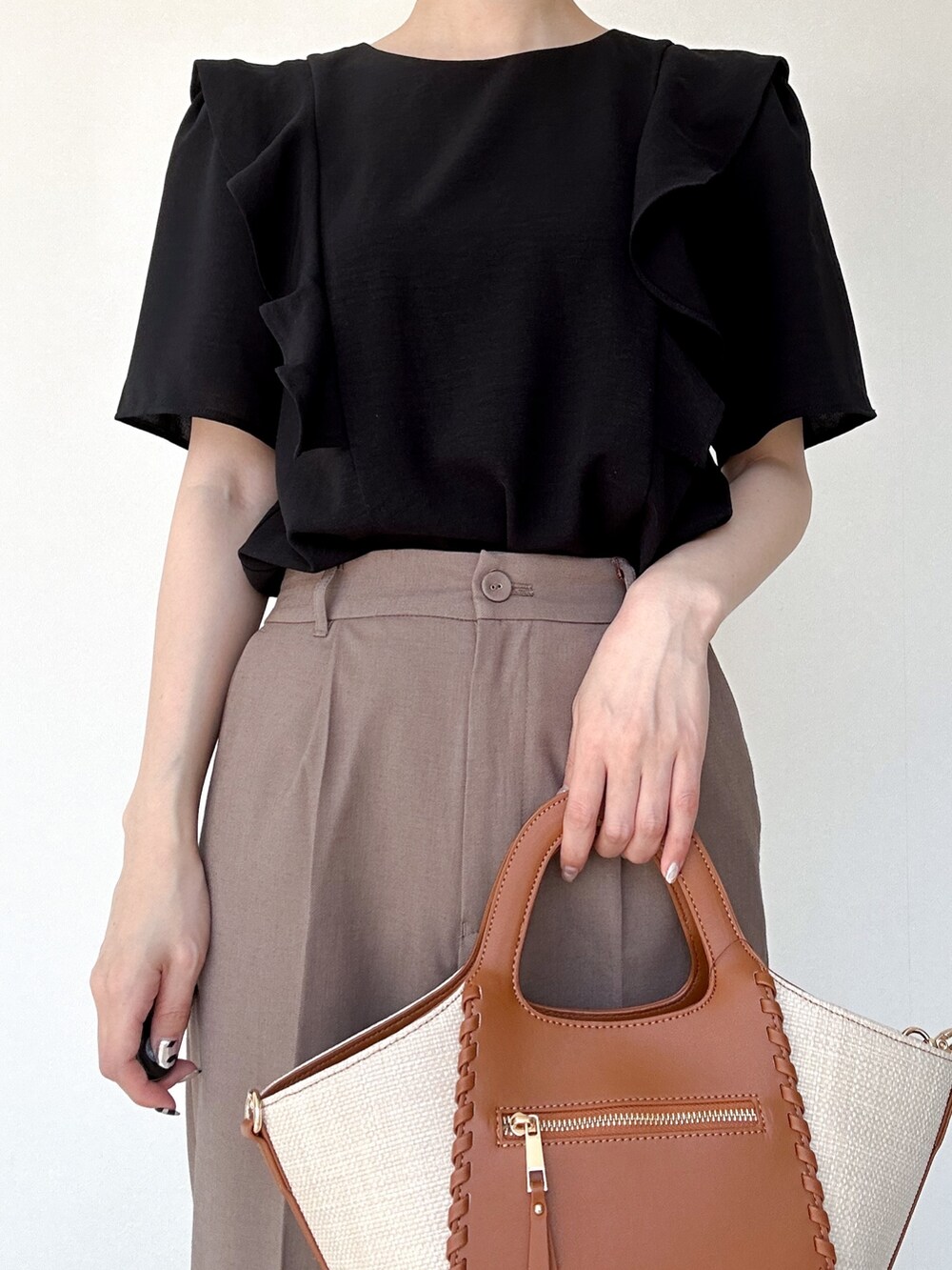 ブラック系のセットアップ、ブラウン系のその他パンツ、イエロー系のトートバッグを着用したレディースの春コーディネートの4枚目の写真