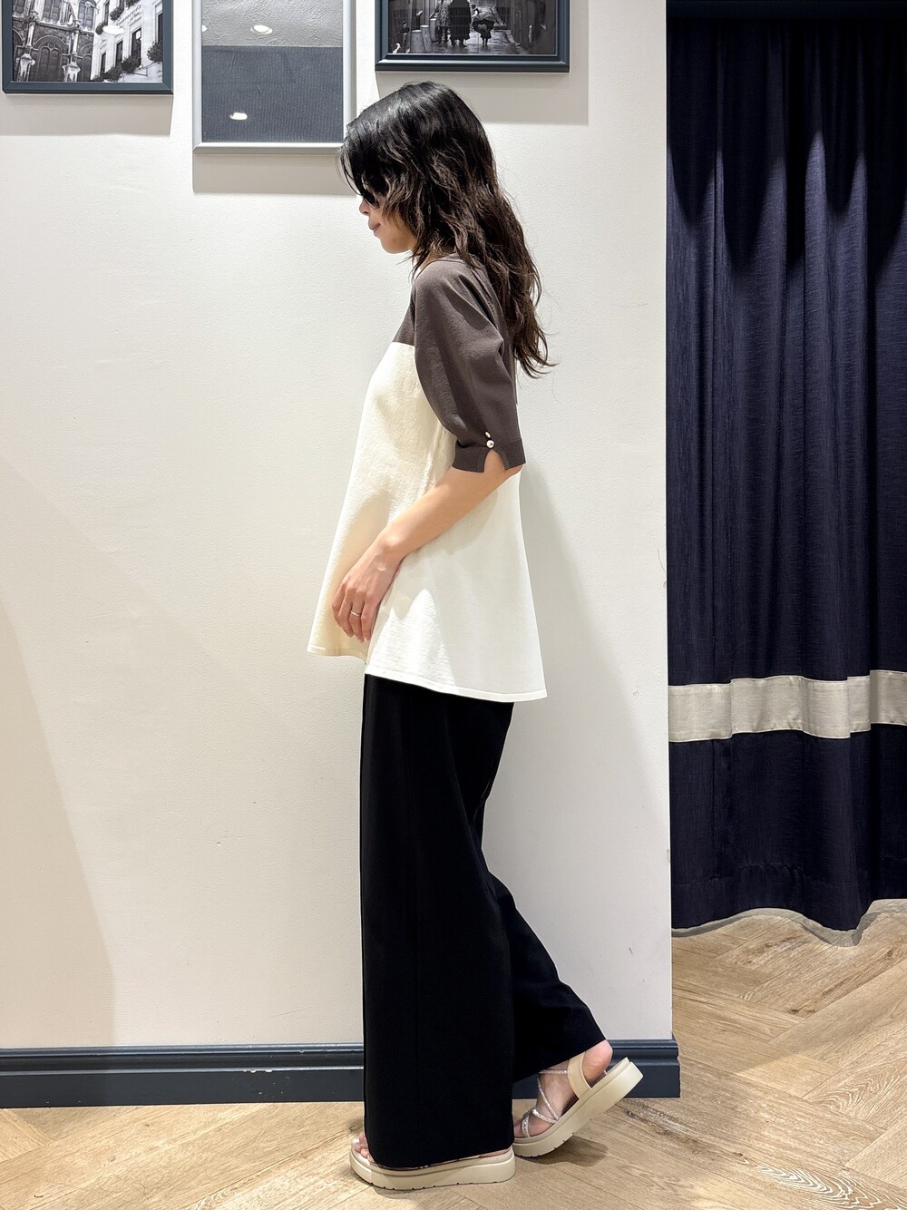 ベージュ系のニット/セーター、ブラック系のその他パンツ、ゴールド系のネックレスを着用したレディースの夏コーディネートの2枚目の写真