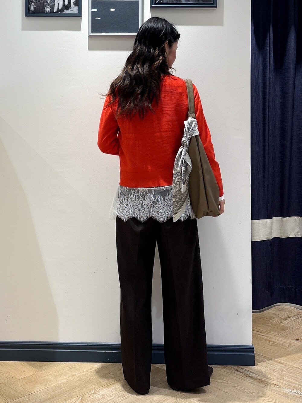 レッド系のニット/セーター、ホワイト系のTシャツ/カットソー、ブラウン系のその他パンツを着用したレディースの秋コーディネートの3枚目の写真