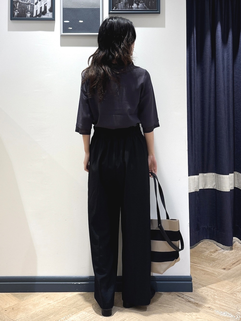 グレー系のニット/セーター、ブラック系のその他パンツ、ブラック系のトートバッグを着用したレディースの秋コーディネートの3枚目の写真