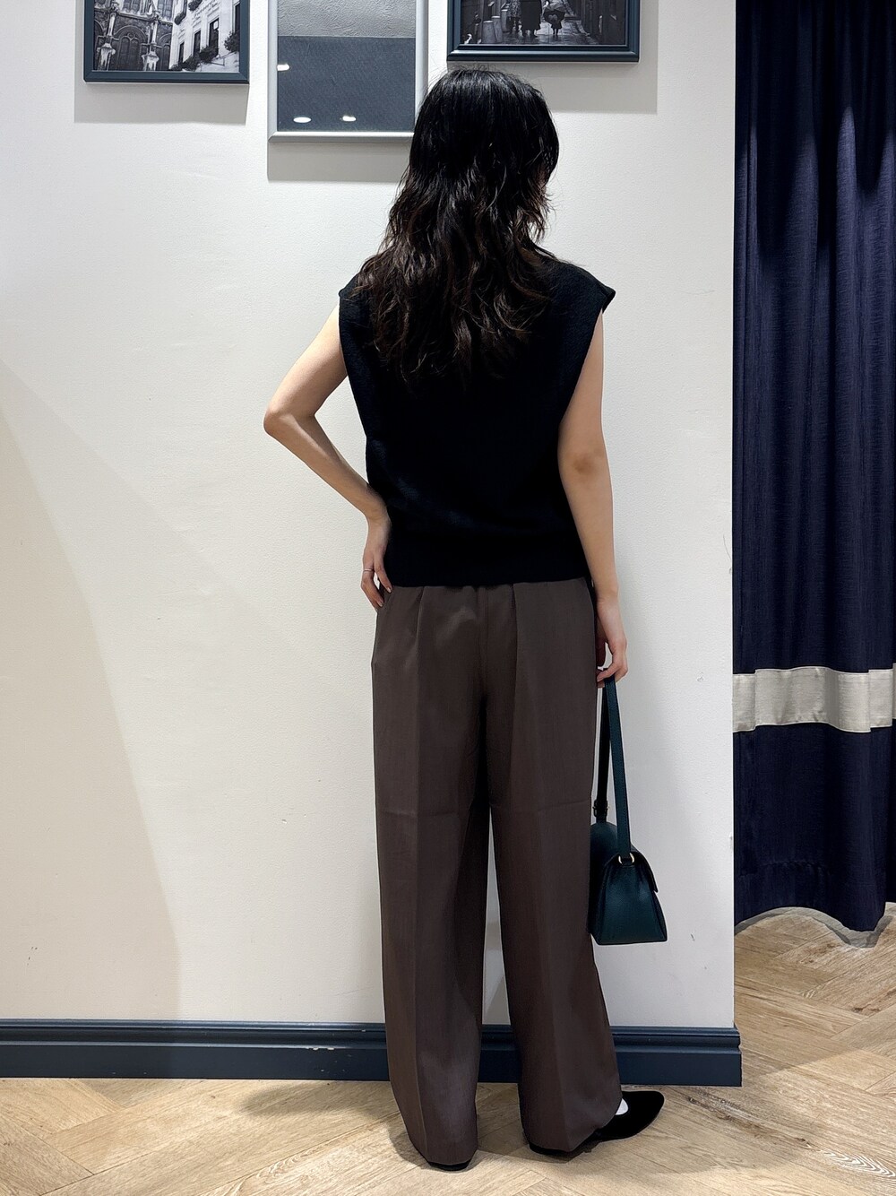 ブラック系のニット/セーター、ブラウン系のその他パンツ、グリーン系のショルダーバッグを着用したレディースの夏コーディネートの3枚目の写真