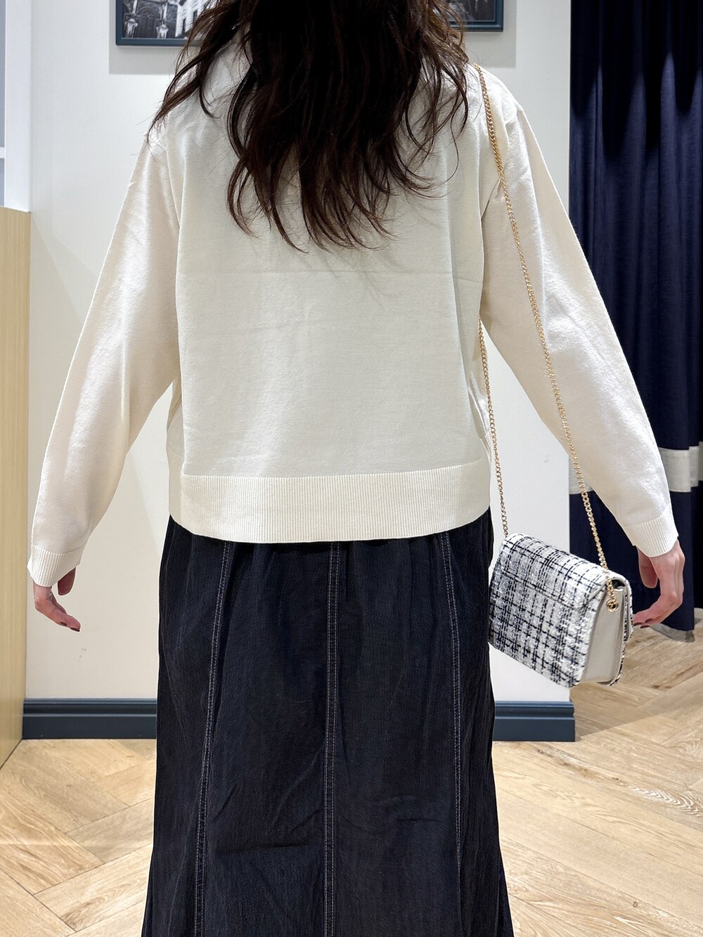 ホワイト系のカーディガン/ボレロ、グレー系のタンクトップ、ブラック系のデニムスカートを着用したレディースの秋コーディネートの6枚目の写真