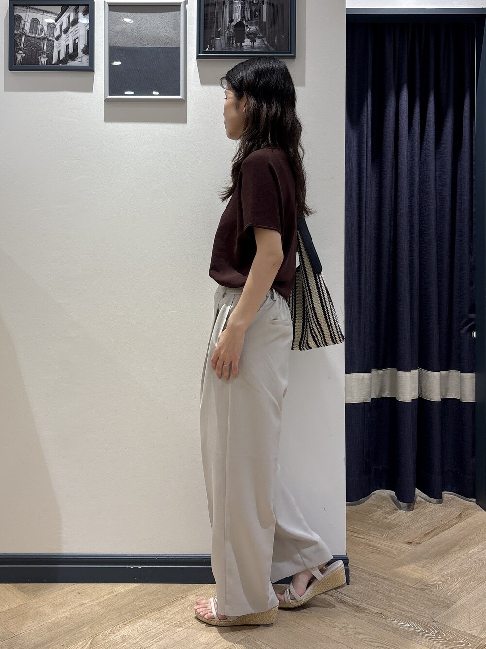 ブラウン系のニット/セーター、ベージュ系のその他パンツ、ブラック系のショルダーバッグを着用したレディースの夏コーディネートの2枚目の写真