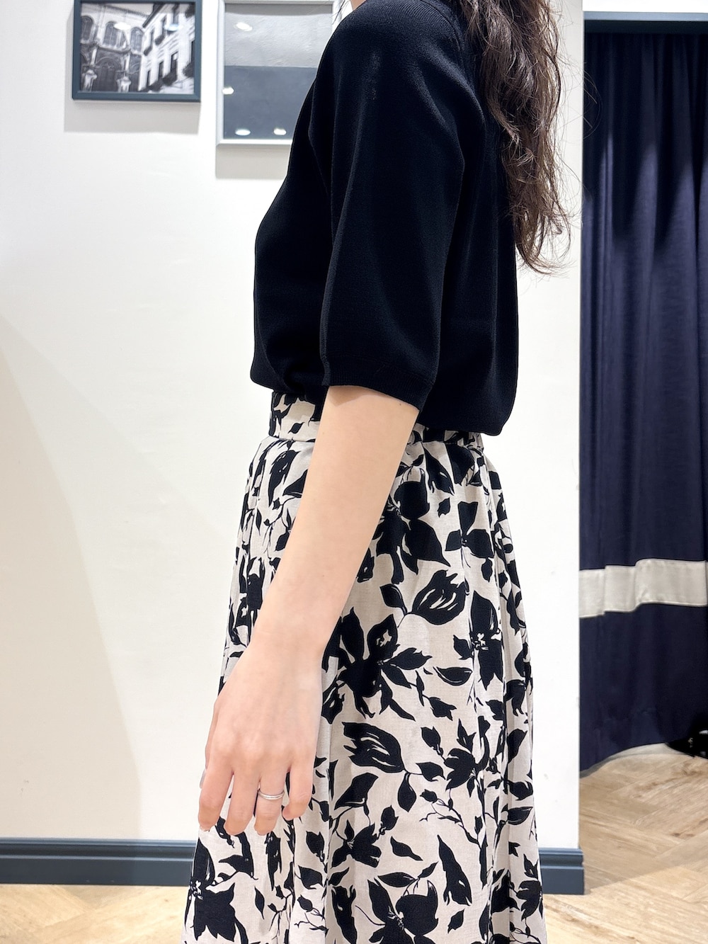 ブラック系のニット/セーター、ベージュ系のスカート、シルバー系のネックレスを着用したレディースの夏コーディネートの5枚目の写真