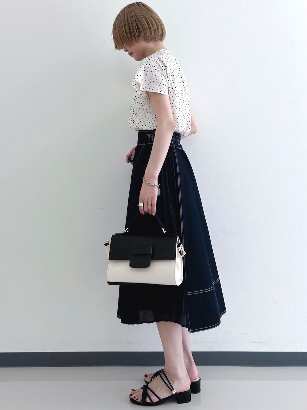 ベージュ系のシャツ/ブラウス、ブルー系のスカート、ブラック系のショルダーバッグを着用したレディースの春コーディネートの2枚目の写真