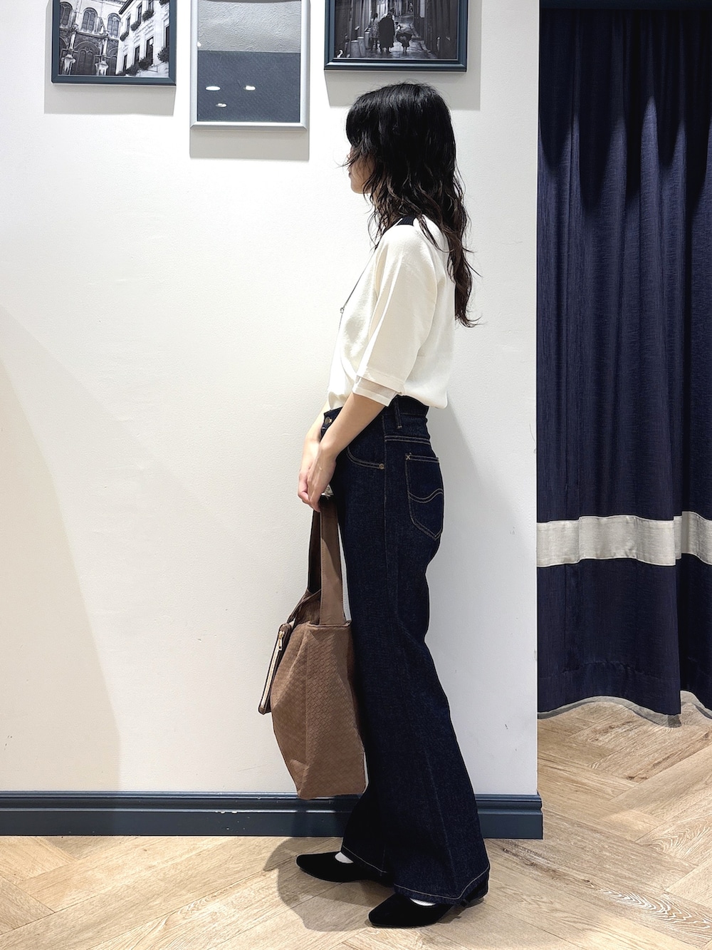 ホワイト系のニット/セーター、ブルー系のデニムパンツ、イエロー系のショルダーバッグを着用したレディースの秋コーディネートの2枚目の写真