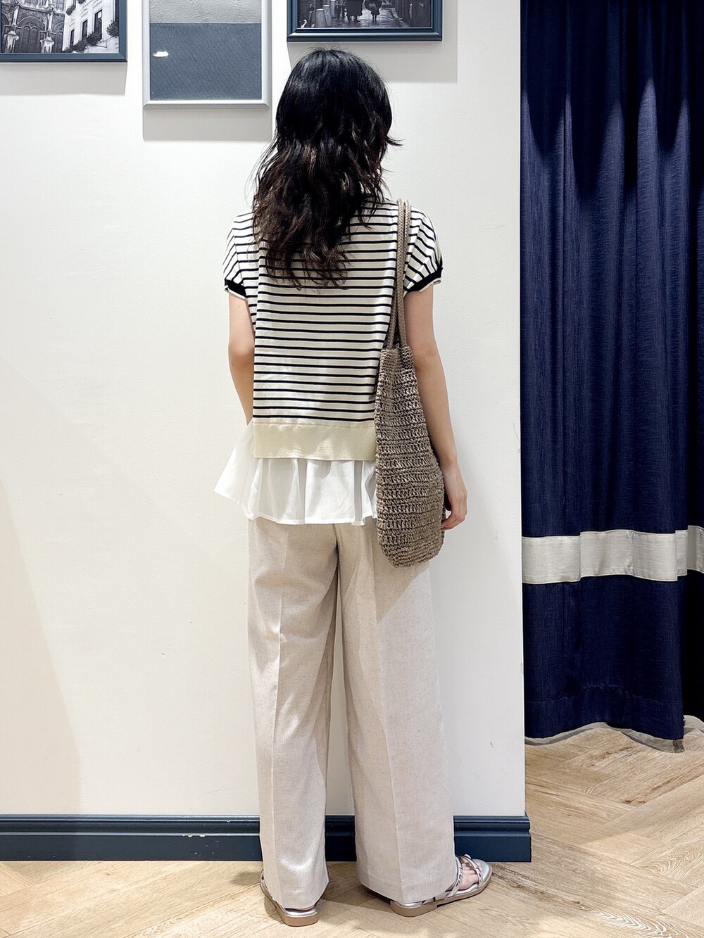 ホワイト系のニット/セーター、ベージュ系のその他パンツ、ブラウン系のトートバッグを着用したレディースの夏コーディネートの3枚目の写真
