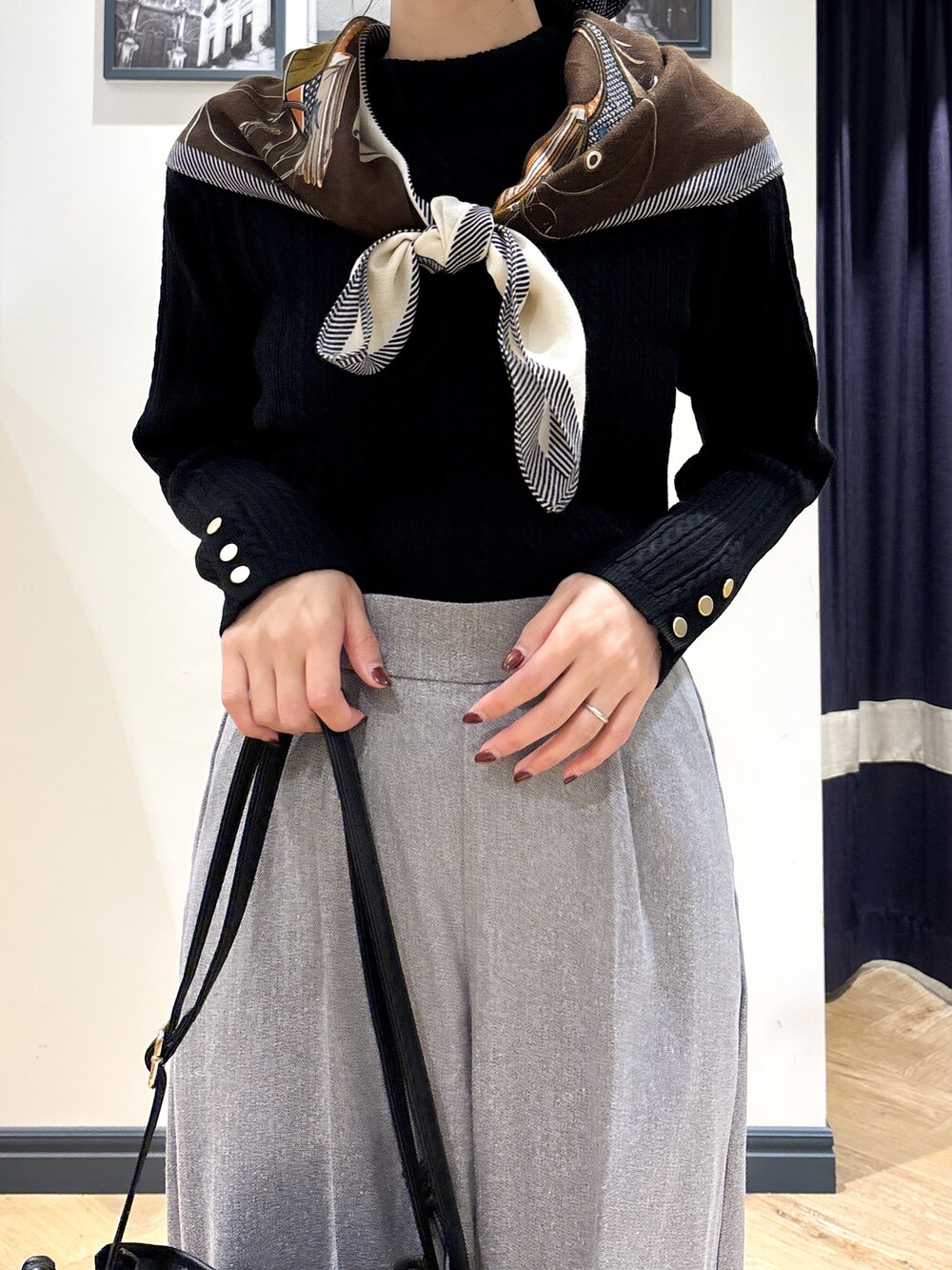 ブラック系のニット/セーター、グレー系のその他パンツ、ブラック系のショルダーバッグを着用したレディースの秋コーディネートの4枚目の写真