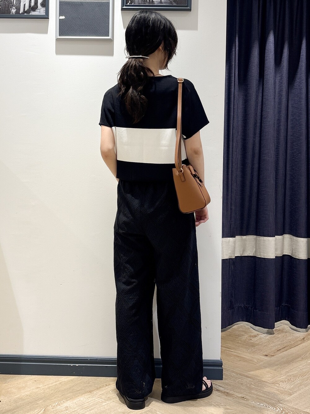 ブラック系のニット/セーター、ブラック系のその他パンツ、イエロー系のショルダーバッグを着用したレディースの春コーディネートの3枚目の写真