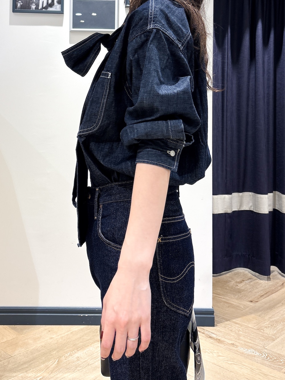 ブルー系のシャツ/ブラウス、ブルー系のデニムパンツ、ブラック系のショルダーバッグを着用したレディースの秋コーディネートの5枚目の写真
