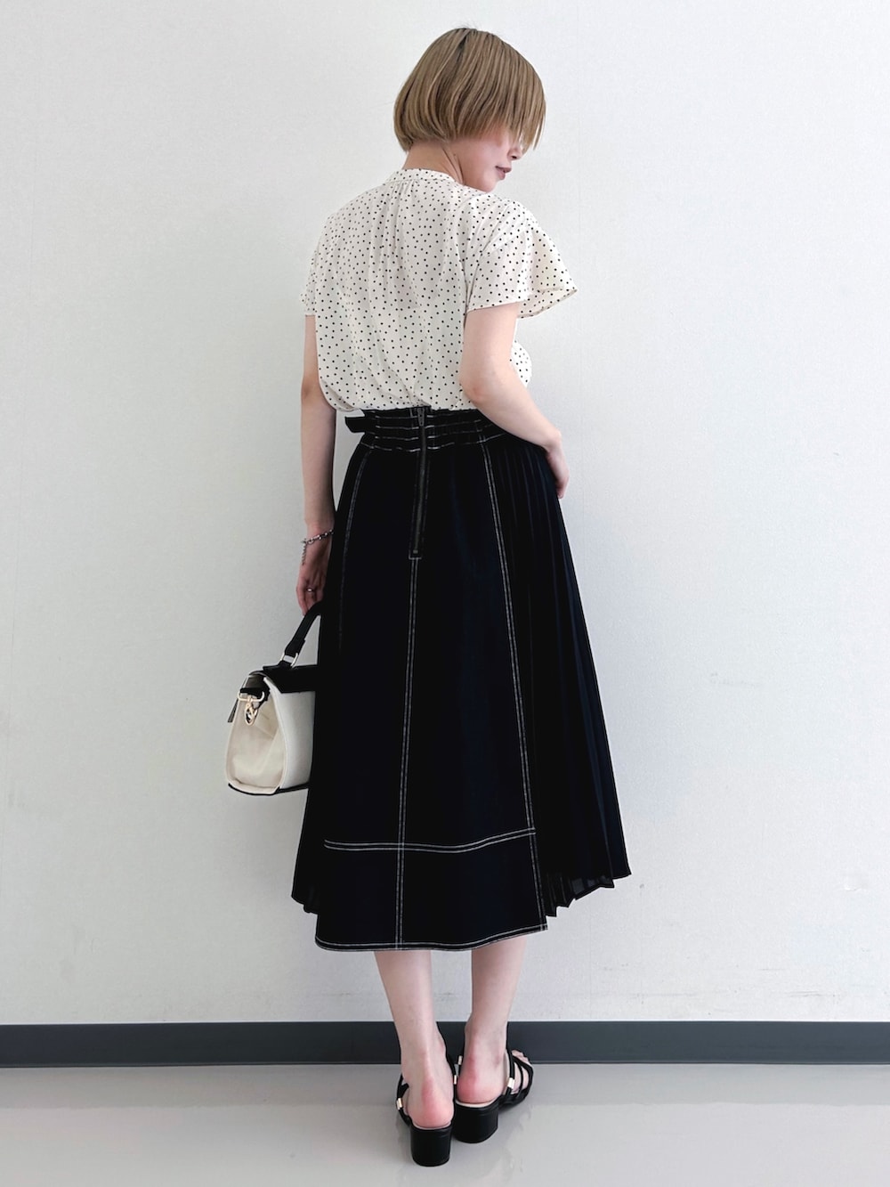 ベージュ系のシャツ/ブラウス、ブルー系のスカート、ブラック系のショルダーバッグを着用したレディースの春コーディネートの3枚目の写真