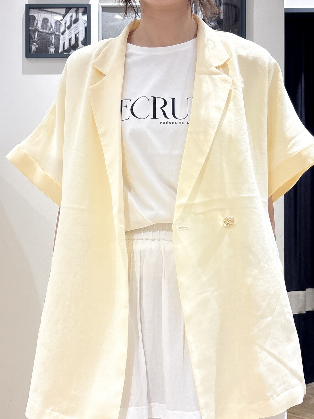 ホワイト系のテーラードジャケット、ホワイト系のTシャツ/カットソー、ホワイト系のスカートを着用したレディースの夏コーディネートの4枚目の写真