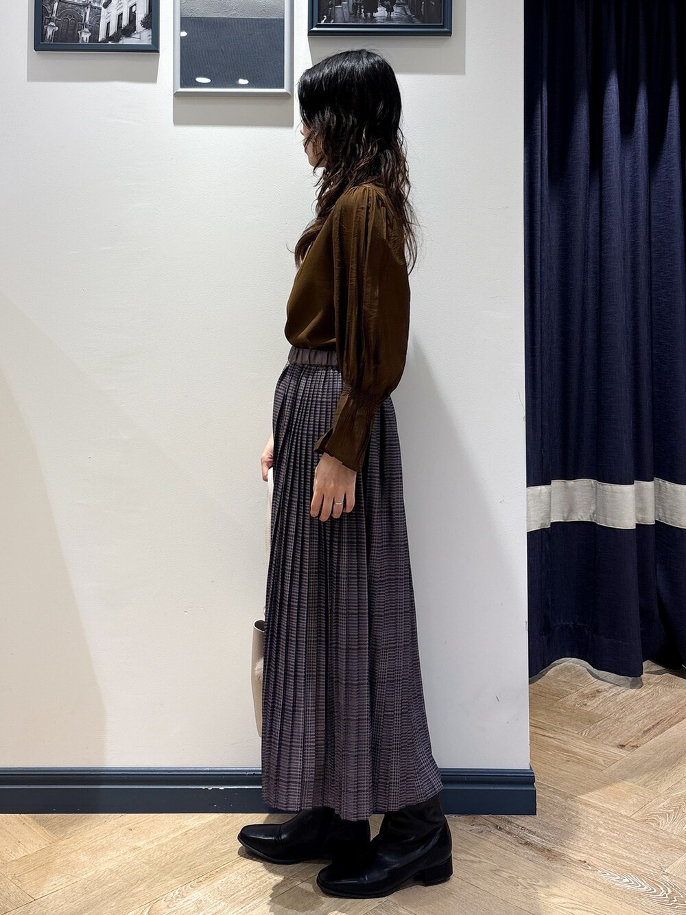 ブラウン系のTシャツ/カットソー、グレー系のスカート、ベージュ系のショルダーバッグを着用したレディースの秋コーディネートの2枚目の写真