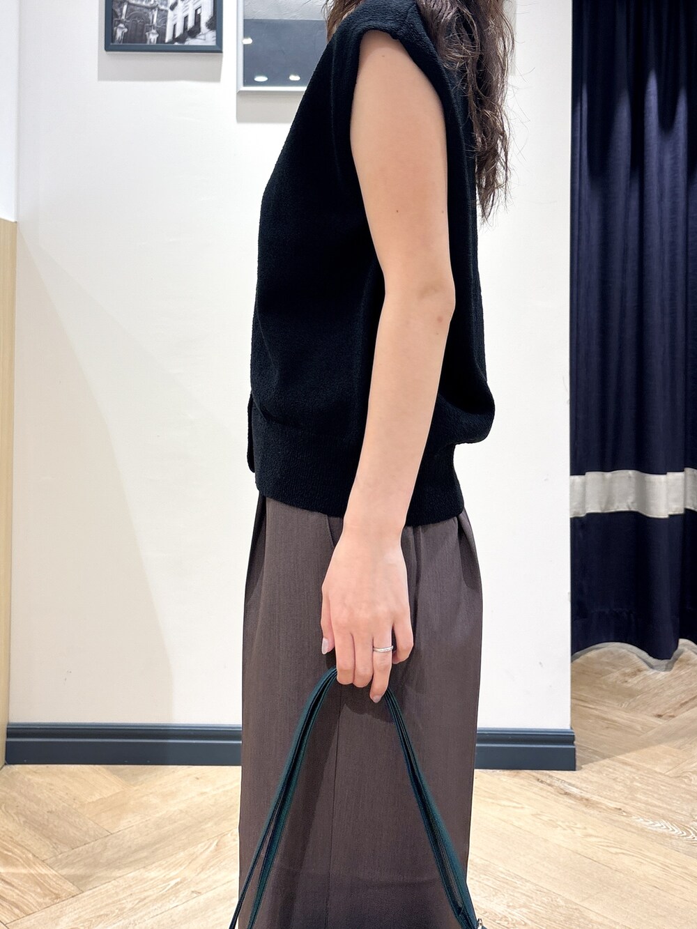 ブラック系のニット/セーター、ブラウン系のその他パンツ、グリーン系のショルダーバッグを着用したレディースの夏コーディネートの5枚目の写真