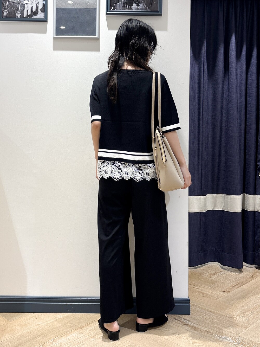 ブラック系のニット/セーター、ブラック系のその他パンツ、ベージュ系のバックパック/リュックを着用したレディースの夏コーディネートの3枚目の写真