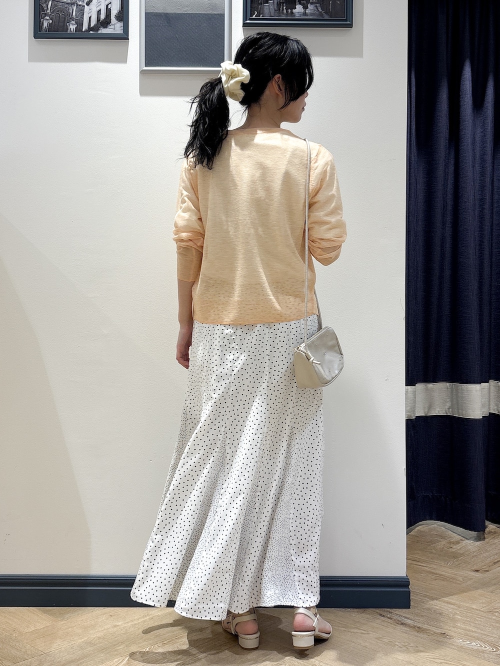 ホワイト系のショルダーバッグ、オレンジ系のカーディガン/ボレロ、ホワイト系のTシャツ/カットソーを着用したレディースの春コーディネートの3枚目の写真